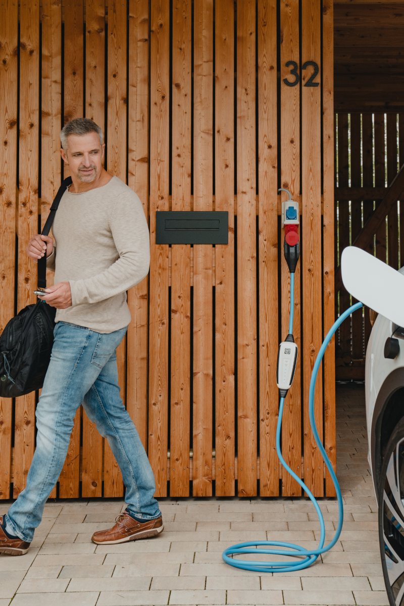 Person mit einem NRGkick, die ein Elektrofahrzeug auflädt